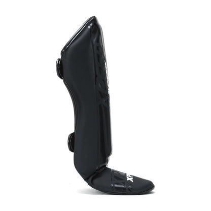 Black matte Xpeed XP3059 stand-up shinguard, lightweight protective gear with adjustable straps for sports use.