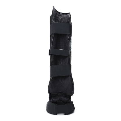 Black Xpeed XP3060 Xpeed Matt PU shinpad with foot strap, designed for protective sports gear.