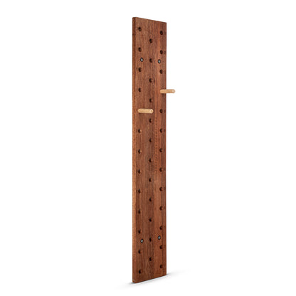 A tall, narrow wooden pegboard wall hook with a warm brown wood finish, featuring multiple round peg holes and two light natural wood hanging bars, shown on a solid white background.