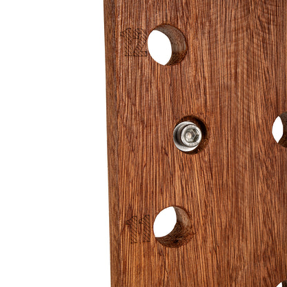 Close-up of a brown wooden panel with three circular cutouts and a central metal mounting screw, shown against a white background.
