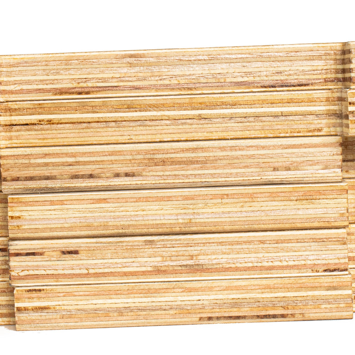 A close-up of stacked, layered wood slats or trim pieces showing natural wood grain and horizontal grooved lines, set against a plain white background.